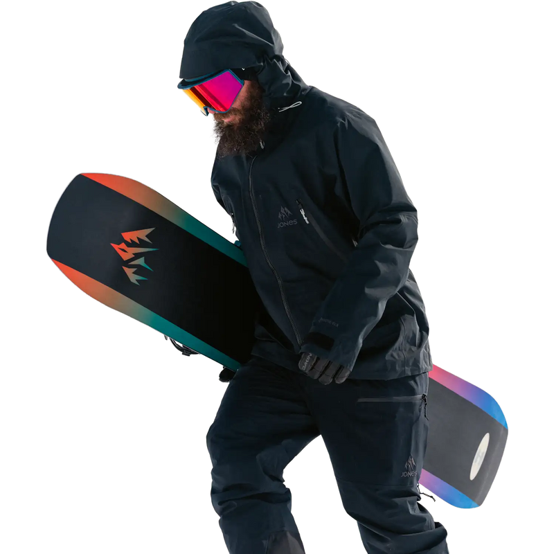 Men's Shralpinist Gore-Tex Recycled 3L Bib, Jones Snowboards Men's Shralpinist Gore-Tex Recycled 3L Bib Stealth Black on model walking with snowboard