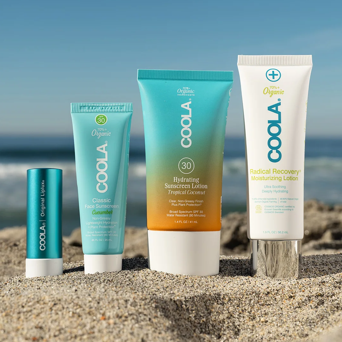 COOLA Travel Essentials Set 4 Piece on sandy beach