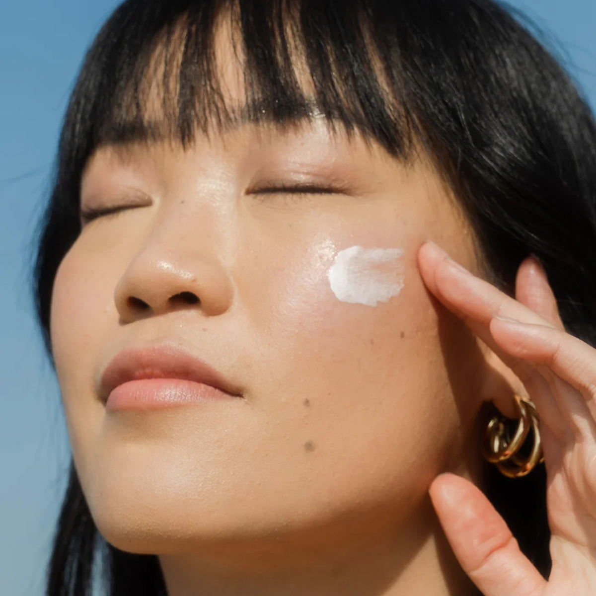 COOLA Travel Essentials SPF 30 Face Sunscreen Lotion being rubbed on face