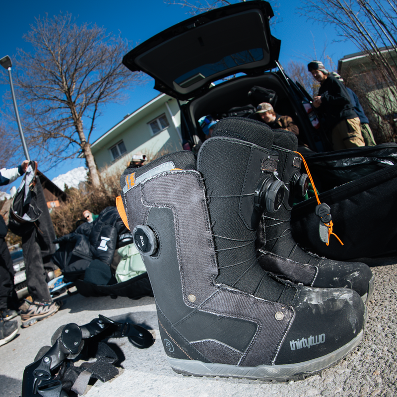 ThirtyTwo STW Double BOA Public pair on ground with snowboarders enjoying an apres ski session