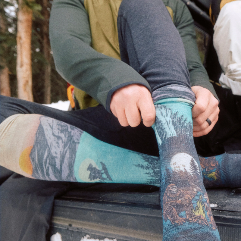 Ski Targeted Cushion Winter Phase Print OTC Socks, Smartwool Ski Targeted Cushion Winter Phase Print OTC Socks lifestyle putting on sock outdoors
