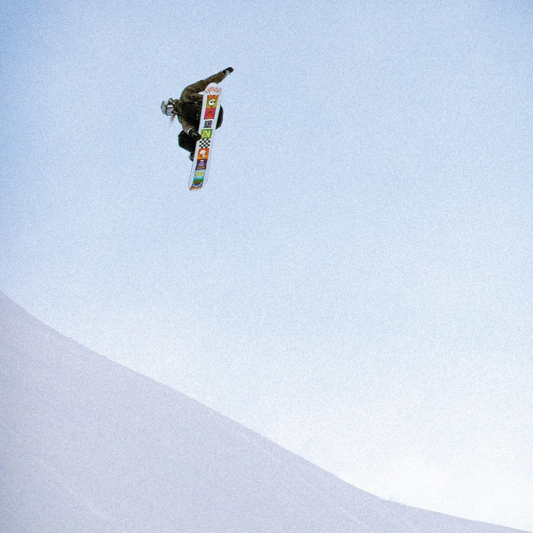 Armada Snowboards Women's Do-Si-Do with rider flying midair over snow covered hill